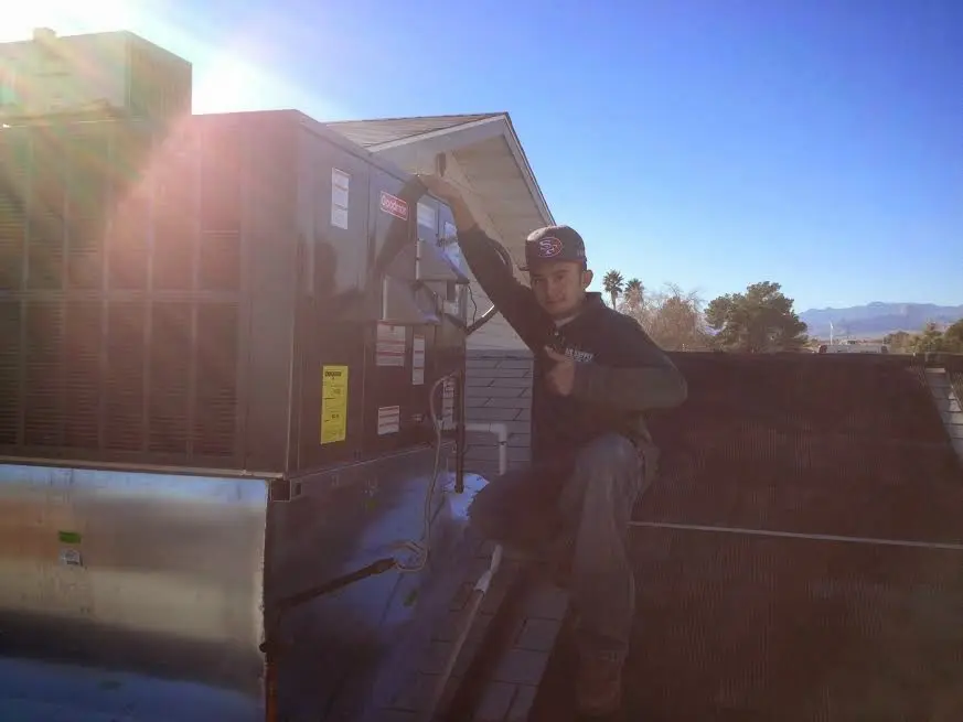 HVAC technician performing AC Tune-Up on a rooftop unit in Humboldt